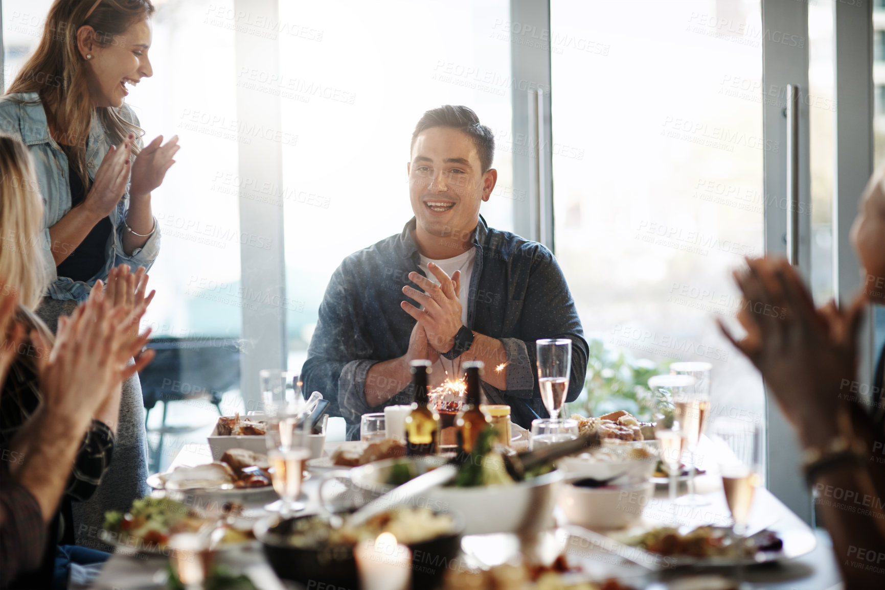 Buy stock photo Shot of a young man celebrating his birthday with his friends