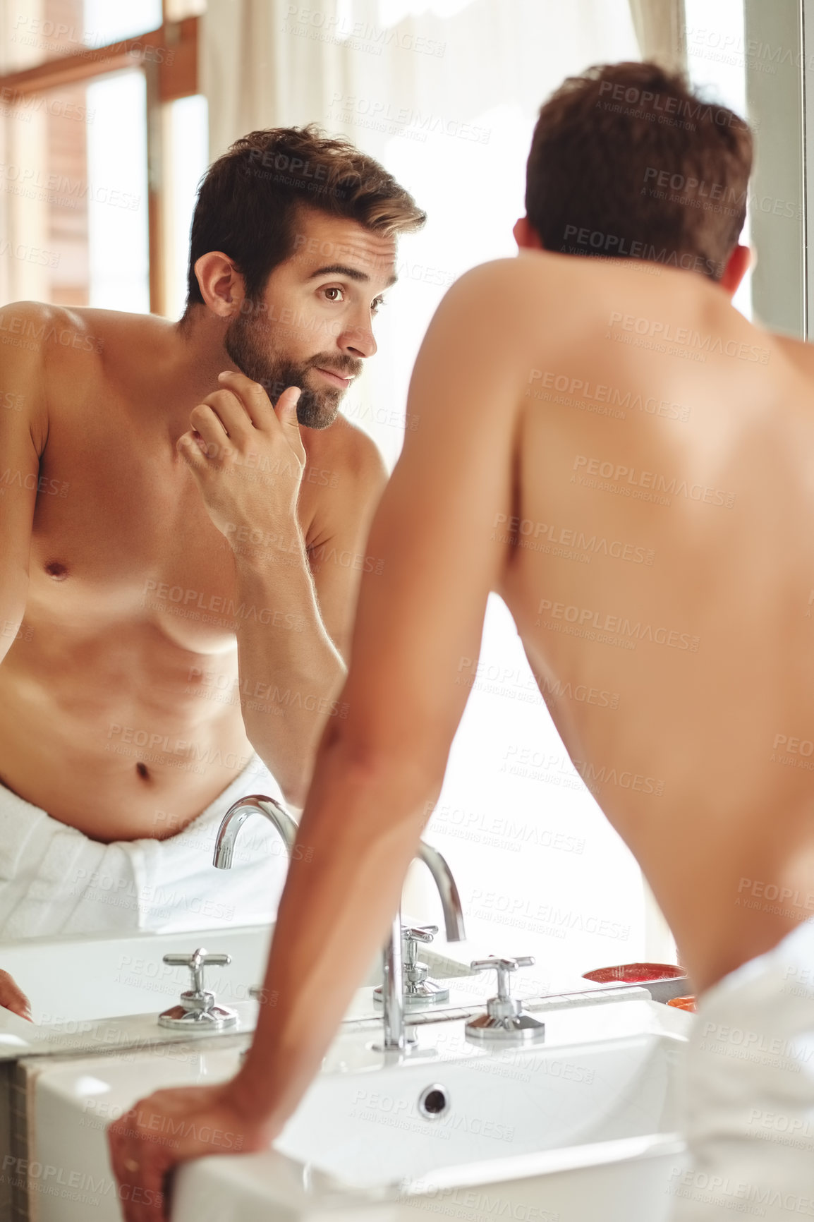 Buy stock photo Cropped shot of a shirtless young man checking out his skin in the bathroom mirror