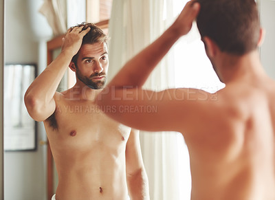 Buy stock photo Cropped shot of a shirtless young man checking out his hair in the bathroom mirror