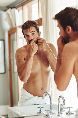 Buy stock photo Cropped shot of a shirtless young man popping pimples in the bathroom mirror