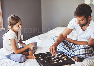 Buy stock photo Cropped shot of a young father playing a board game with his adorable little daughter at home