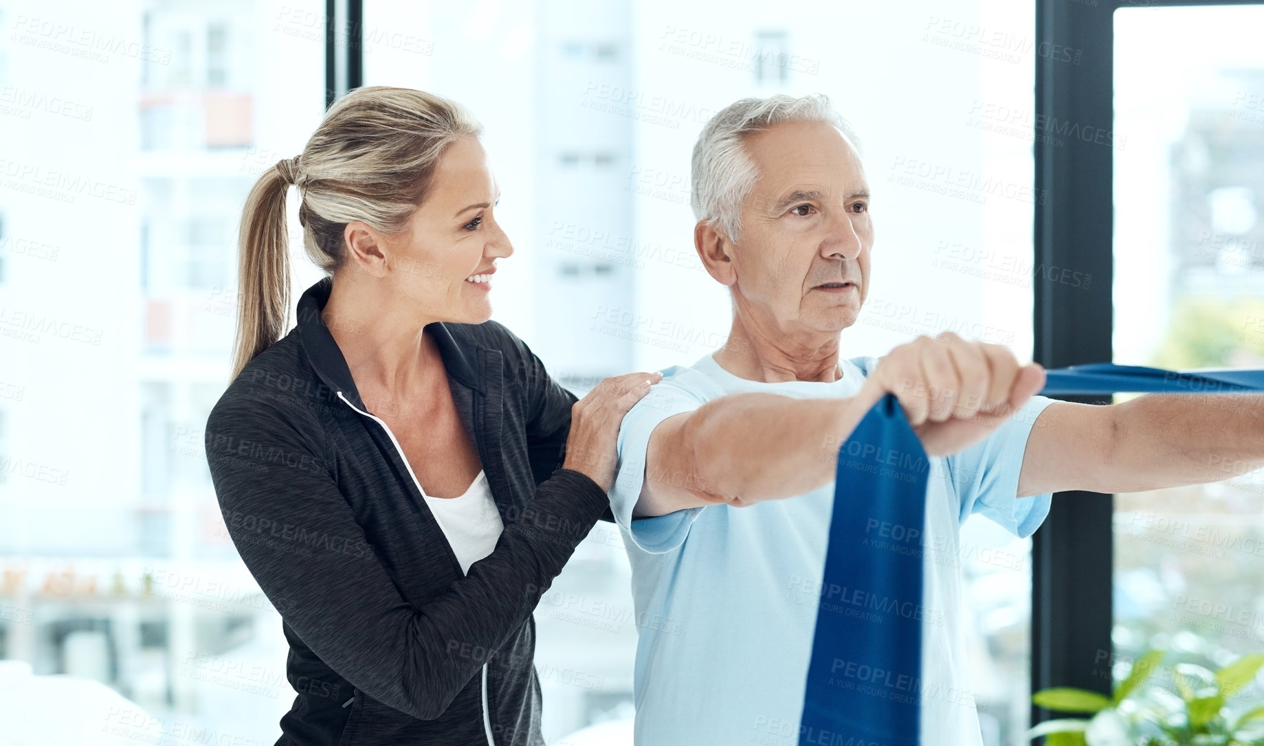 Buy stock photo Shot of a a physiotherapist working with a senior patient using a resistance band