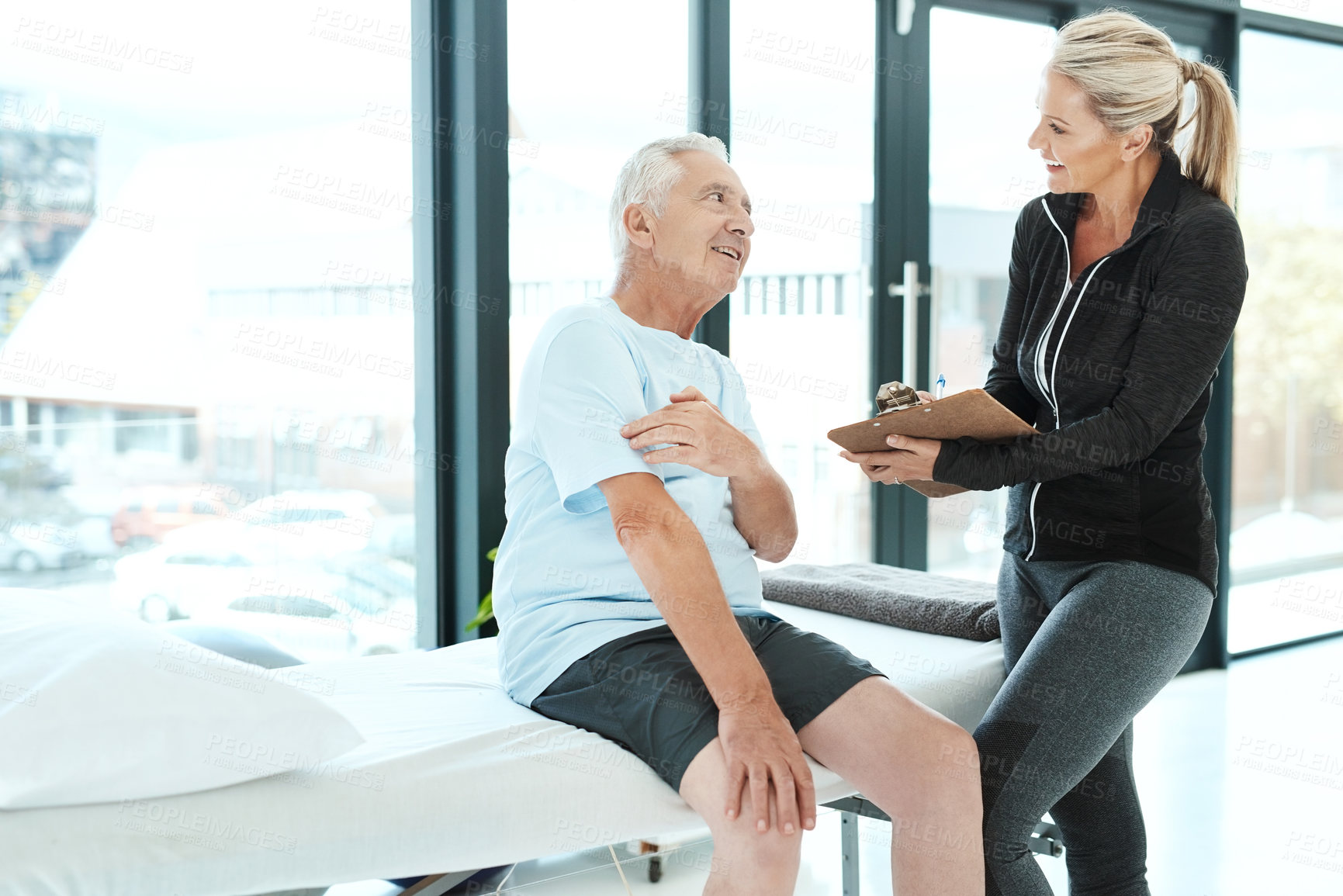Buy stock photo Shot of a senior man consulting with his physiotherapist in her office