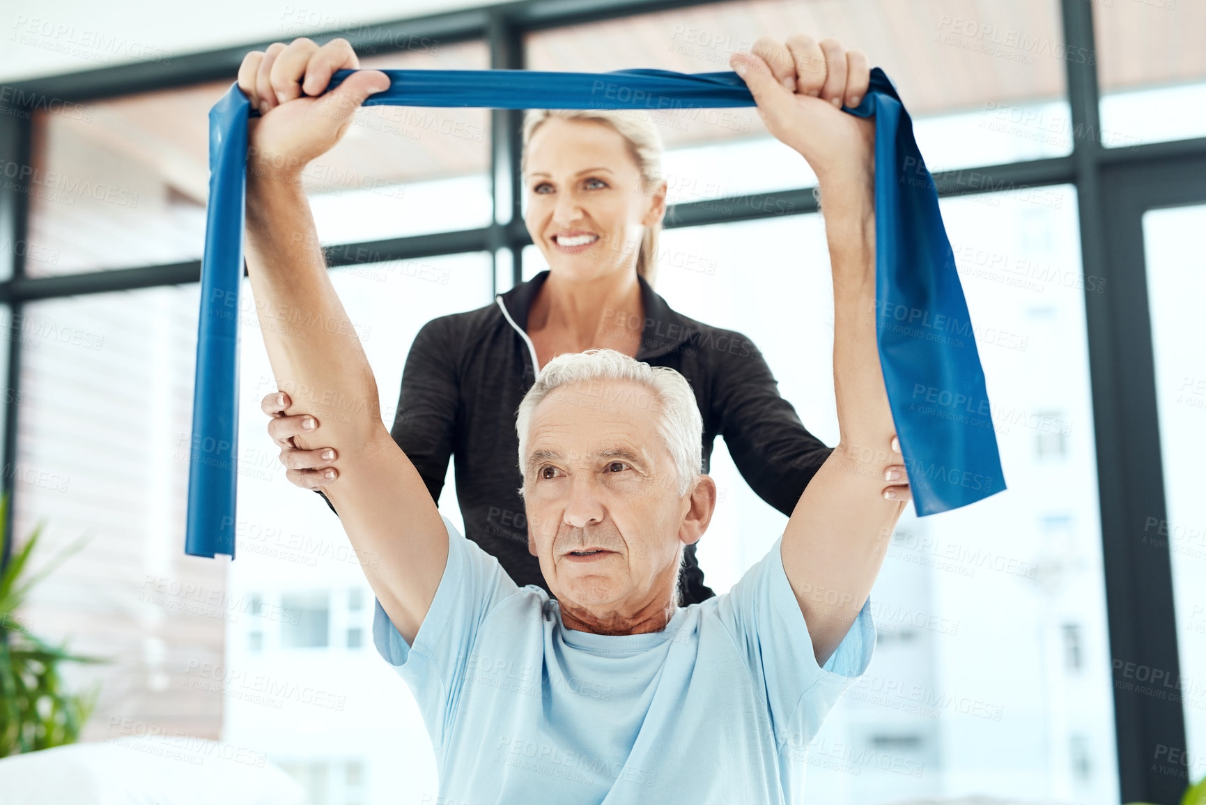 Buy stock photo Shot of a a physiotherapist working with a senior patient using a resistance band