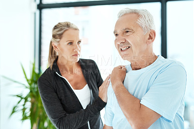 Buy stock photo Shot of a senior man consulting with his physiotherapist in her office