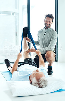 Buy stock photo Shot of a a physiotherapist working with a senior patient using a resistance band