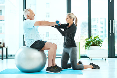 Buy stock photo Shot of a physiotherapists helping her senior patient with his exercises in a fitness center