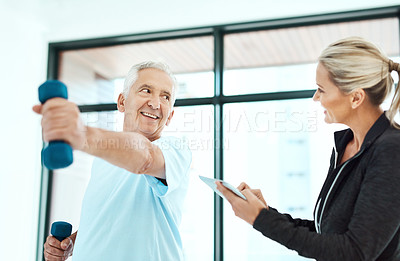 Buy stock photo Shot of a physiotherapists helping her senior patient with his exercises in a fitness center