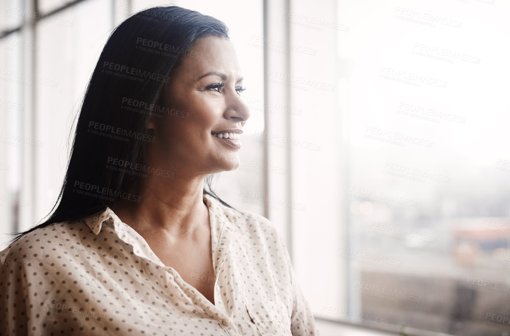 Buy stock photo Shot of a mature businesswoman looking out a window in an office