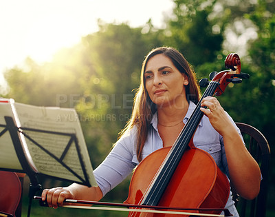 Buy stock photo Cropped shot of a beautiful woman playing a cello in the backyard