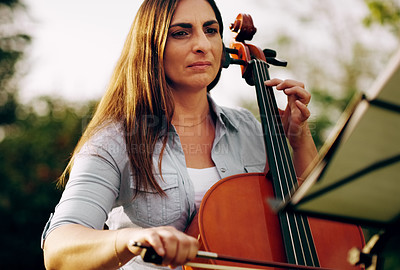 Buy stock photo Cropped shot of a beautiful woman playing a cello in the backyard