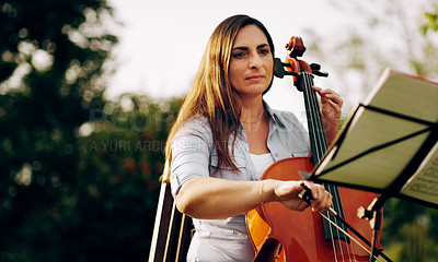 Buy stock photo Cropped shot of a beautiful woman playing a cello in the backyard