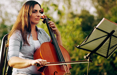 Buy stock photo Cropped shot of a beautiful woman playing a cello in the backyard