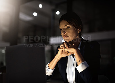 Buy stock photo Shot of a young businesswoman using a laptop during a late at night in a modern office
