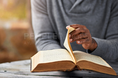 Buy stock photo Hands, spiritual and a man reading the bible at a table outdoor in the park for faith or belief in god. Book, story and religion with a male christian sitting in the garden for learning or worship