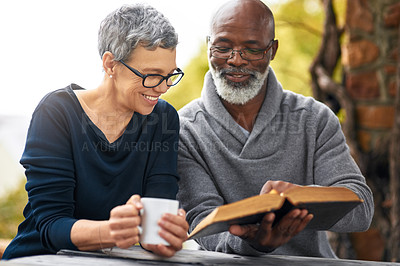 Buy stock photo Cropped shot of an affectionate senior couple reading their bible while sitting outside