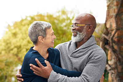 Buy stock photo Interracial senior couple, smile and love in park, garden or nature for hug or care together. Happy man, woman and partner for retirement, relax and support for marriage and vacation for pensioner