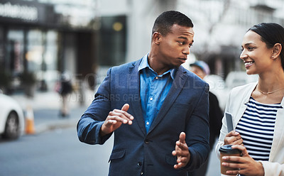 Buy stock photo Shot of two businesspeople having a discussion while walking in the city