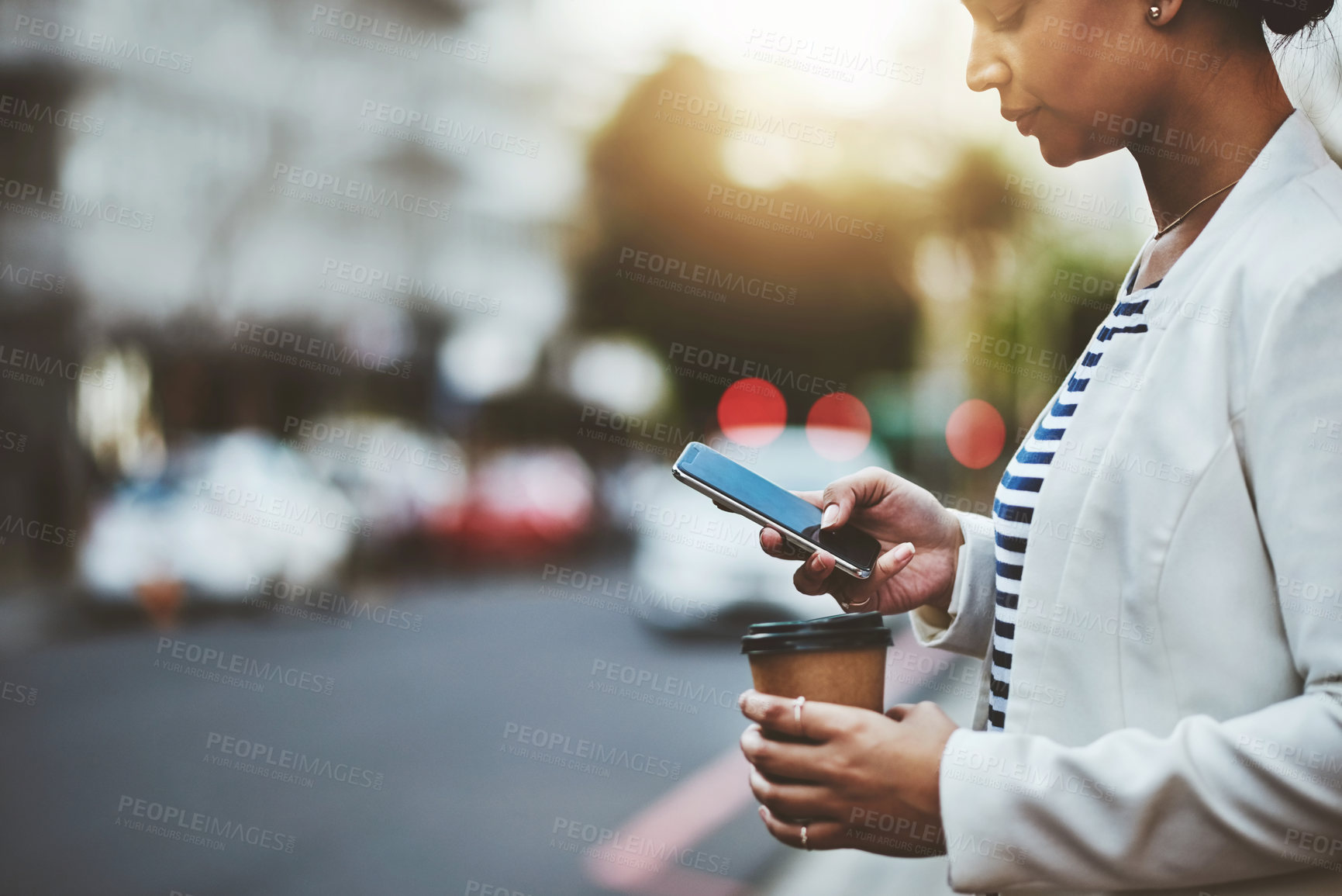 Buy stock photo Shot of a young businesswoman using a cellphone in the city