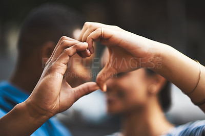 Buy stock photo Cropped shot of a young couple making a heart gesture with their hands outdoors