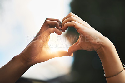 Buy stock photo Cropped shot of a couple making a heart gesture with their hands outdoors