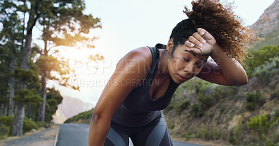 Buy stock photo Shot of a sporty young woman taking a break while exercising outdoors