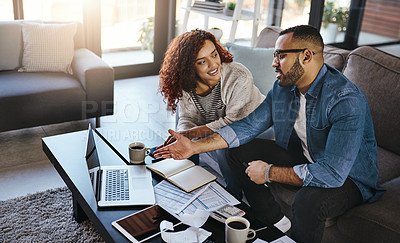 Buy stock photo Shot of a young couple planning their budget together on a laptop at home