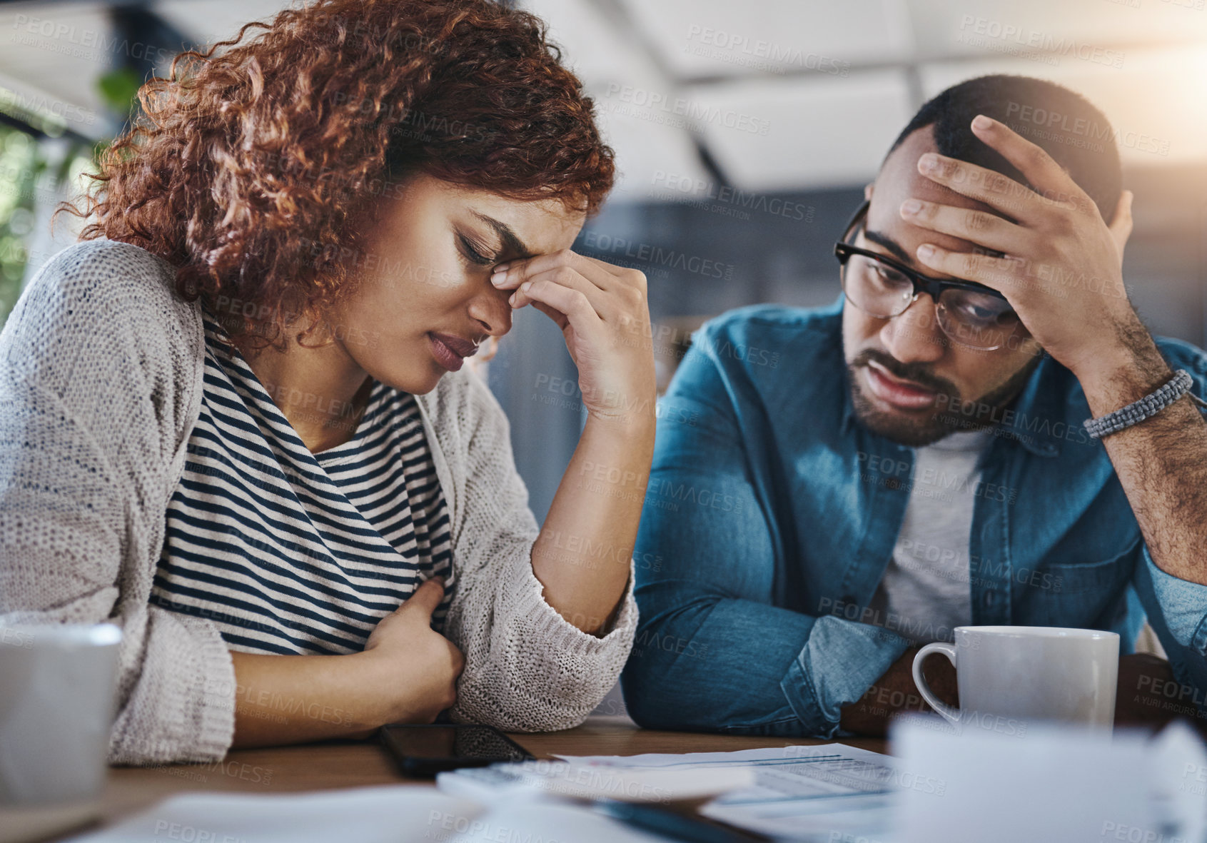 Buy stock photo Shot of a young couple looking stressed out while working on their budget at home