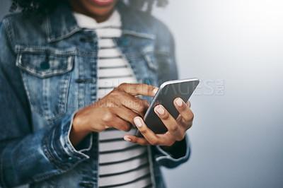 Buy stock photo Hands, phone and woman with chat by wall background for typing email, contact or texting on internet. Student girl, smartphone and web for blog, post or video on social network app for communication