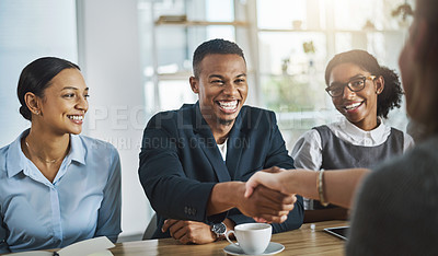 Buy stock photo Cropped shot of two young businesspeople shaking hands during a meeting in the boardroom