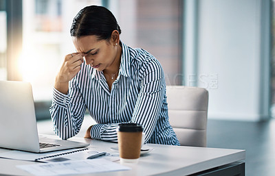 Buy stock photo Shot of a young businesswoman looking stressed out while working in an office