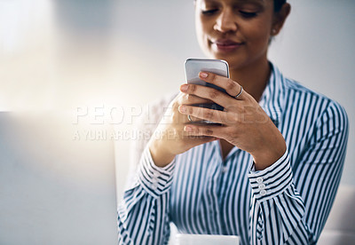 Buy stock photo Shot of a young businesswoman using a cellphone in an office