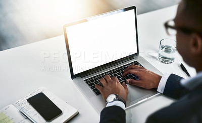 Buy stock photo High angle shot of an unrecognizable young businessman working on his laptop in a modern office