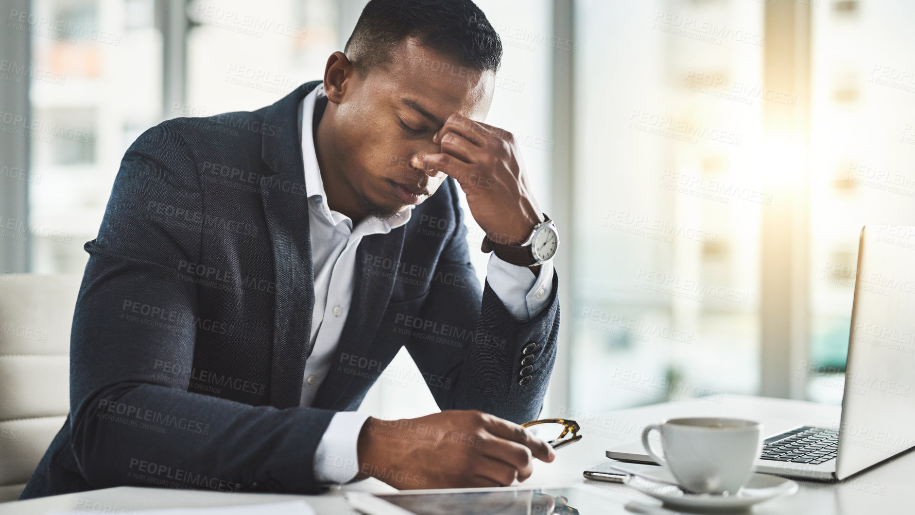 Buy stock photo Cropped shot of a young businessman suffering with a headache while working in his modern office