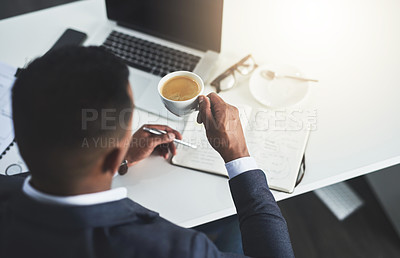 Buy stock photo High angle shot of an unrecognizable young businessman drinking coffee while working in his modern office