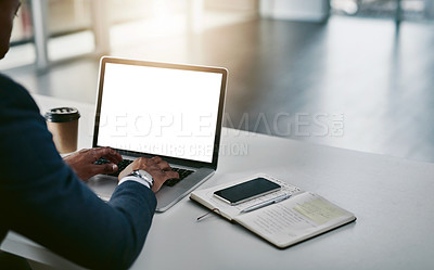 Buy stock photo Cropped shot of an unrecognizable young businessman working on his laptop in a modern office