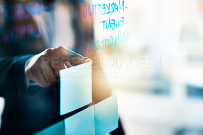 Buy stock photo Closeup shot of an unrecognizable businessman pointing to notes on a glass wall in an office