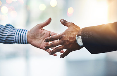 Buy stock photo Closeup shot of two unrecognizable businesspeople shaking hands in an office