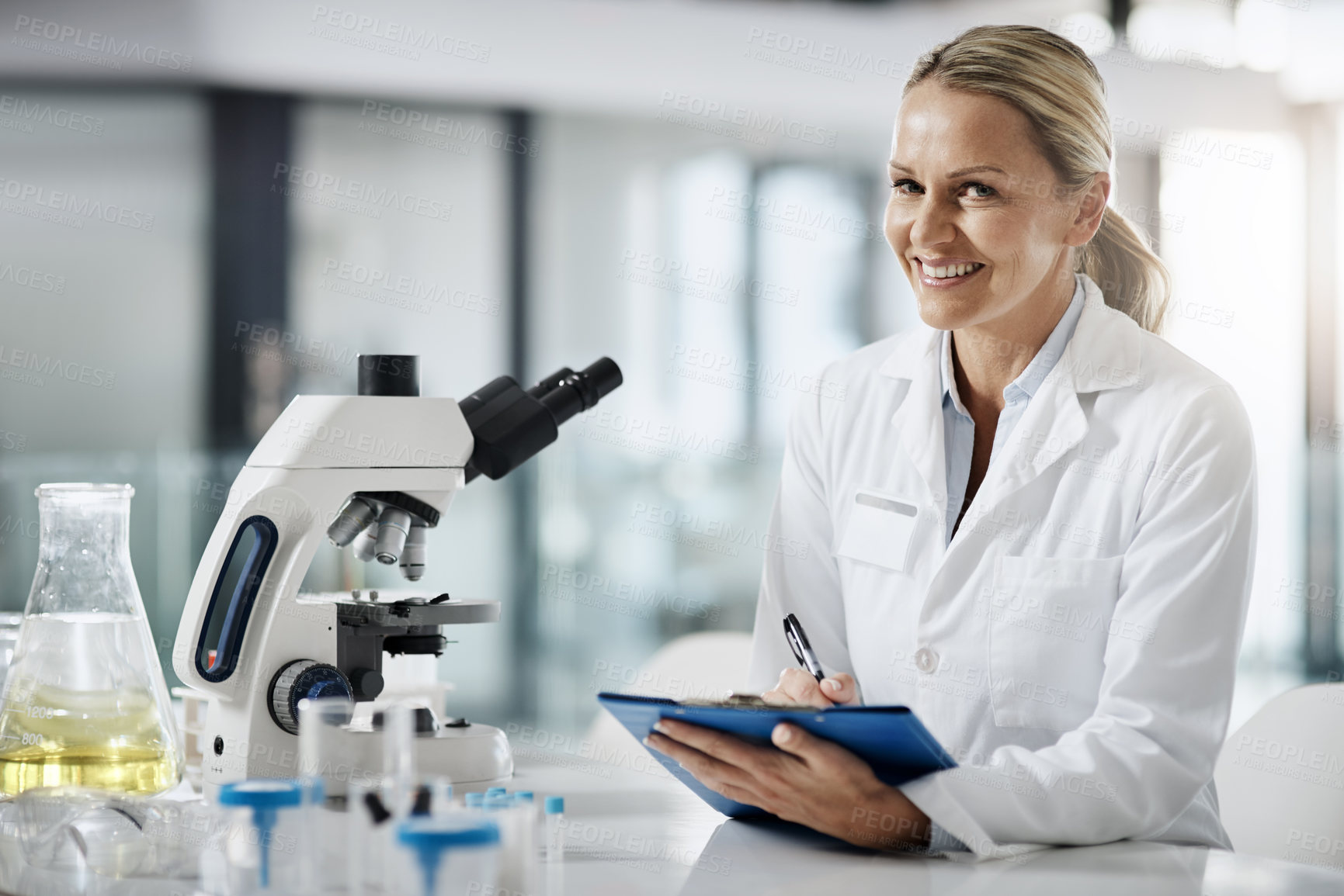 Buy stock photo Cropped portrait of an attractive mature female scientist taking down notes while doing research in her lab