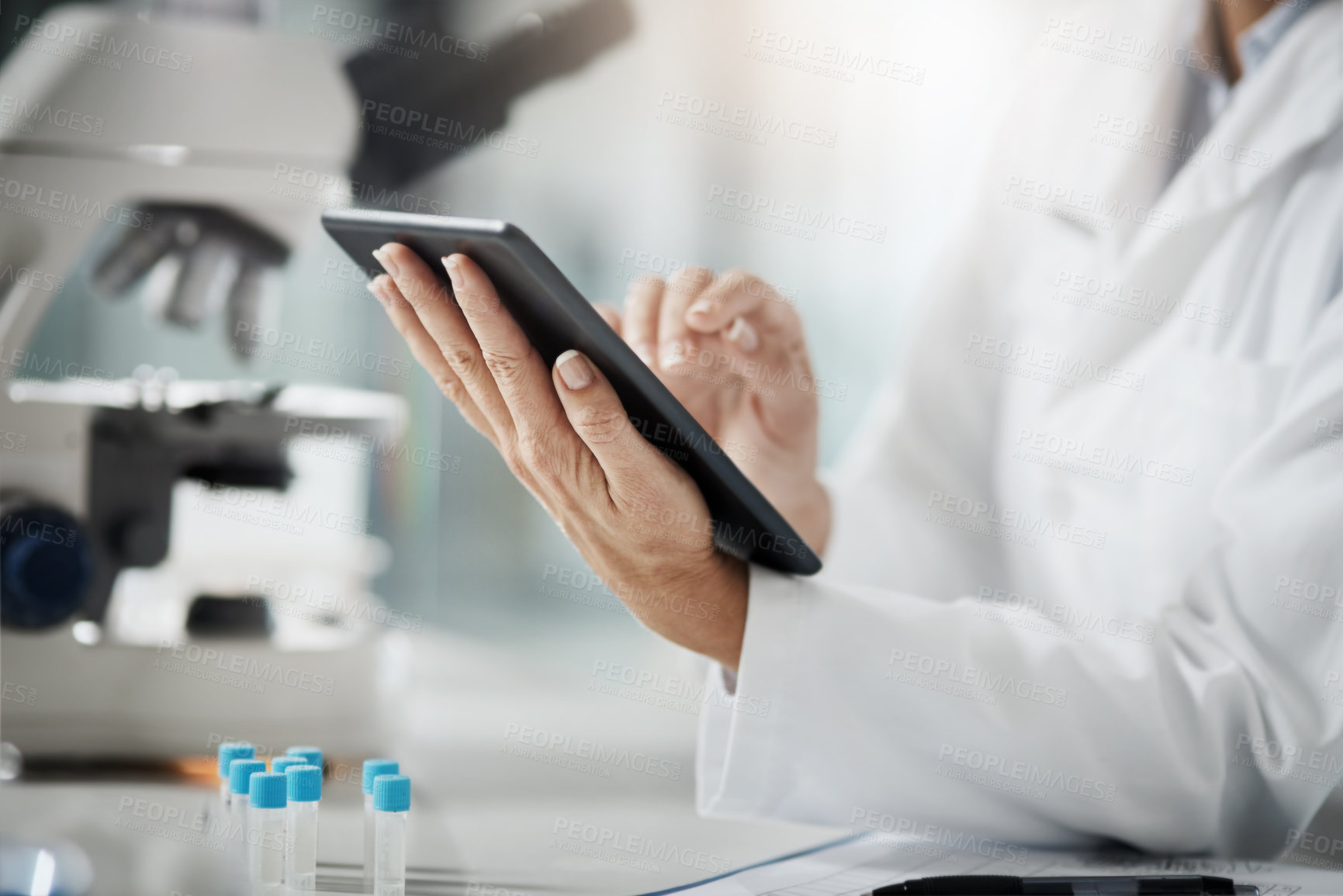 Buy stock photo Cropped shot of an unrecognizable mature female scientist using a tablet while doing research in her lab