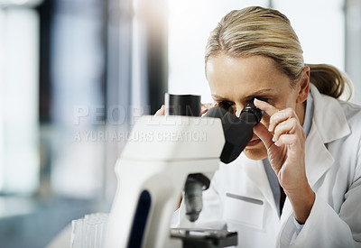 Buy stock photo Cropped shot of an attractive mature female scientist using a microscope while doing research in her lab