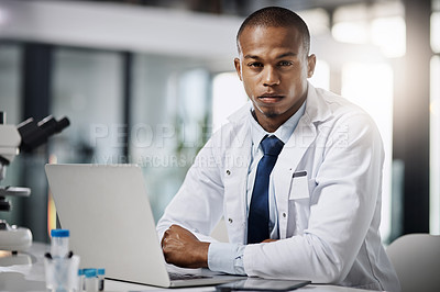 Buy stock photo Cropped portrait of a handsome young male scientist working on a laptop while doing research in his lab