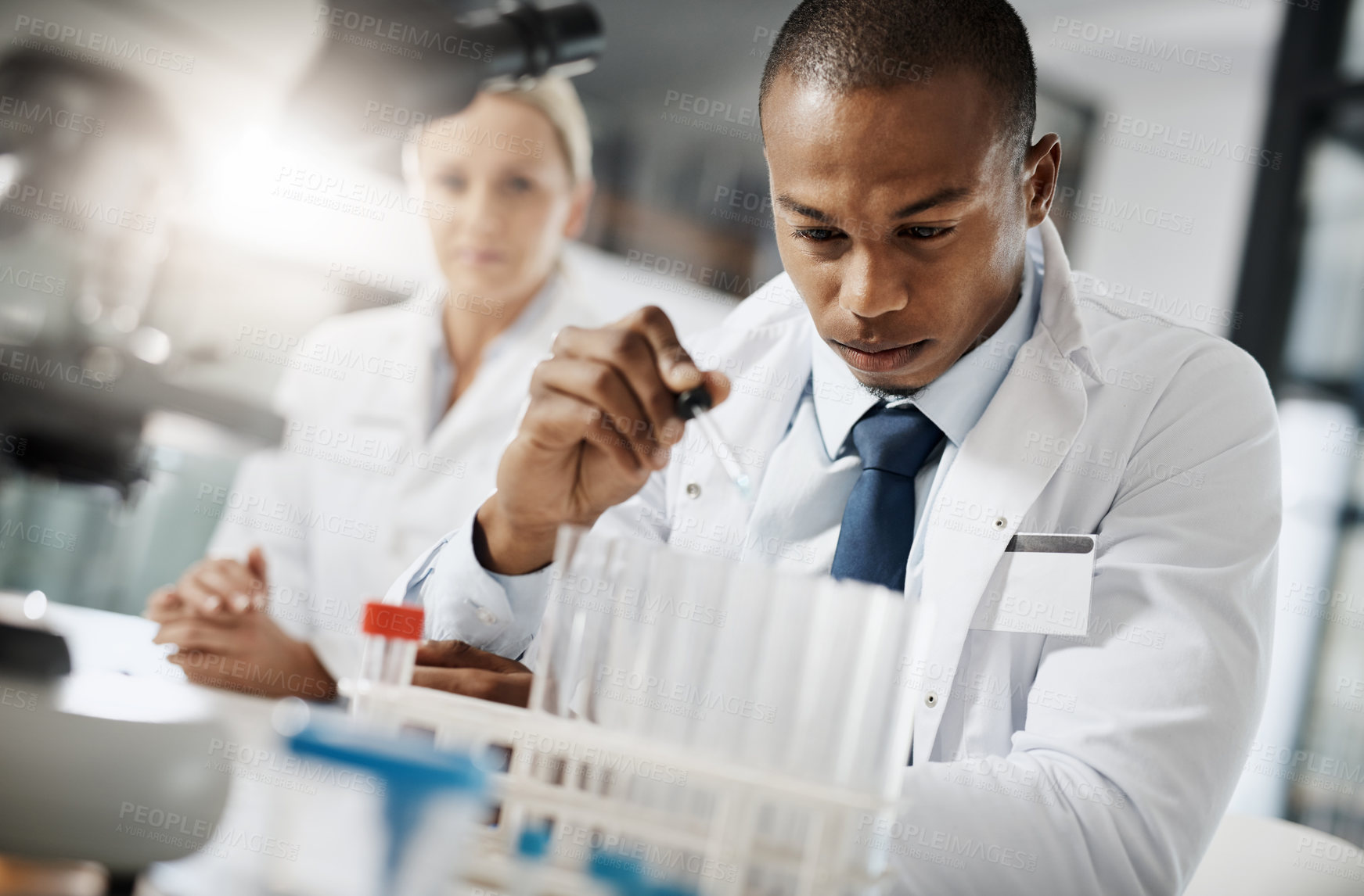 Buy stock photo Cropped shot of a handsome young male scientist testing a sample while doing research in his lab