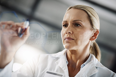 Buy stock photo Cropped shot of an attractive mature female scientist writing down formulas on a glass wipe board while doing research in her lab