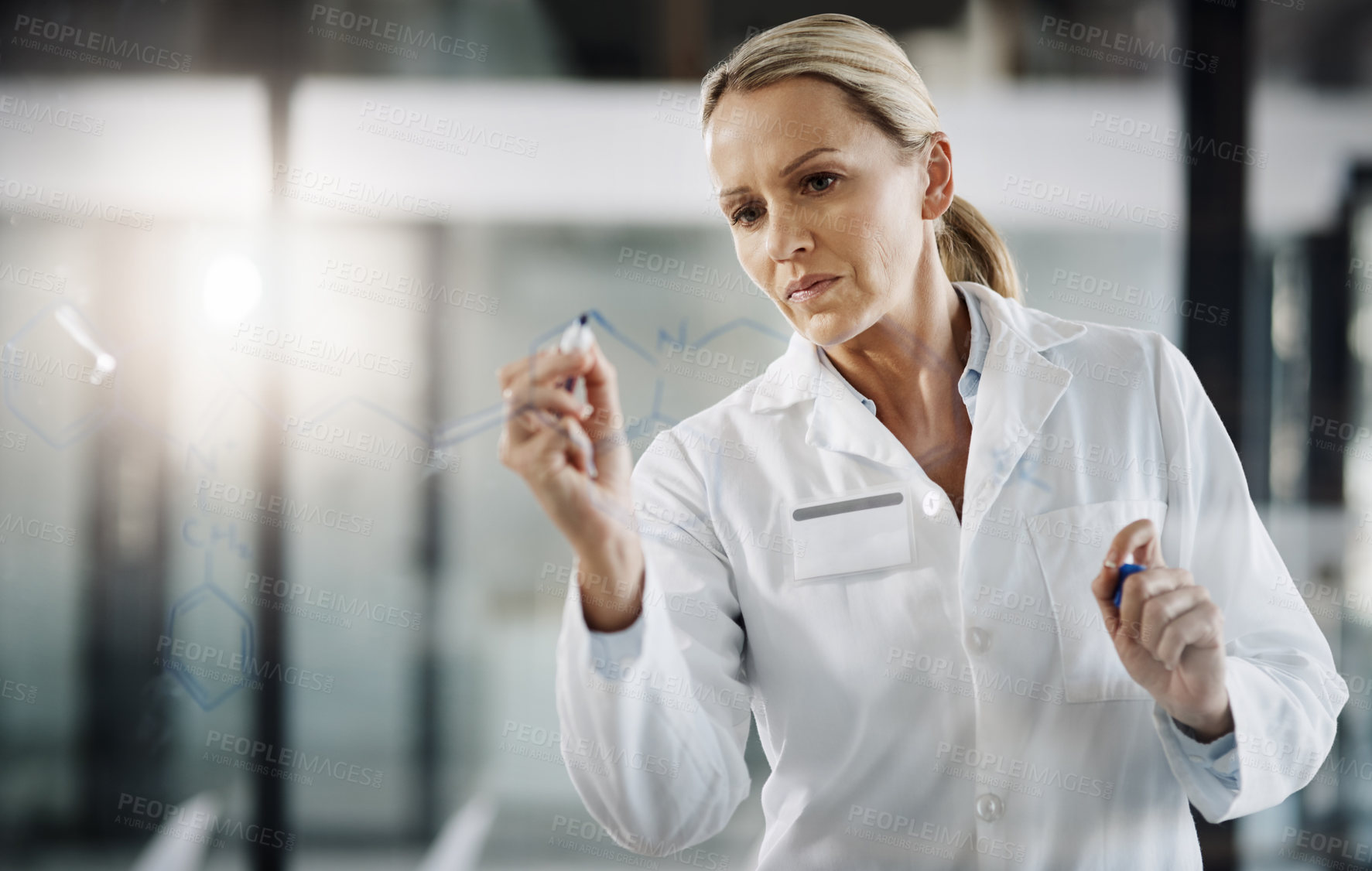 Buy stock photo Cropped shot of an attractive mature female scientist writing down formulas on a glass wipe board while doing research in her lab