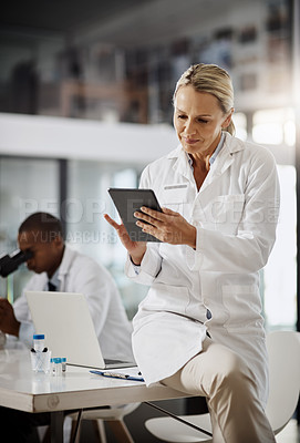 Buy stock photo Cropped shot of an attractive mature female scientist using a tablet while doing research in her lab