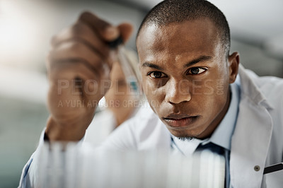 Buy stock photo Cropped shot of a handsome young male scientist testing a sample while doing research in his lab