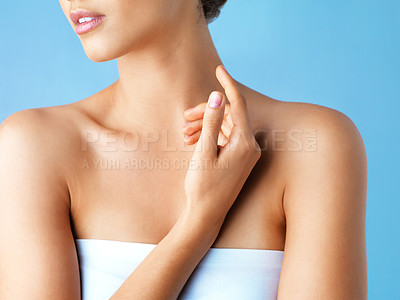 Buy stock photo Cropped studio shot of a beautiful young woman posing against a blue background