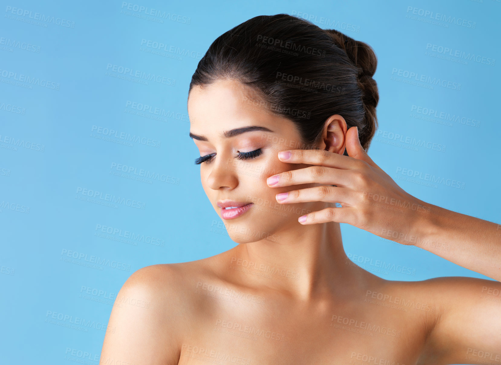 Buy stock photo Studio, face and woman with touch, skincare or cosmetics with natural makeup for healthy skin glow. Beauty, dermatology or girl with confidence, wellness or benefits of facial care on blue background