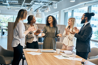 Buy stock photo Shot of a group of cheerful young businesspeople clapping hands after a successful meeting in the office at work during the day